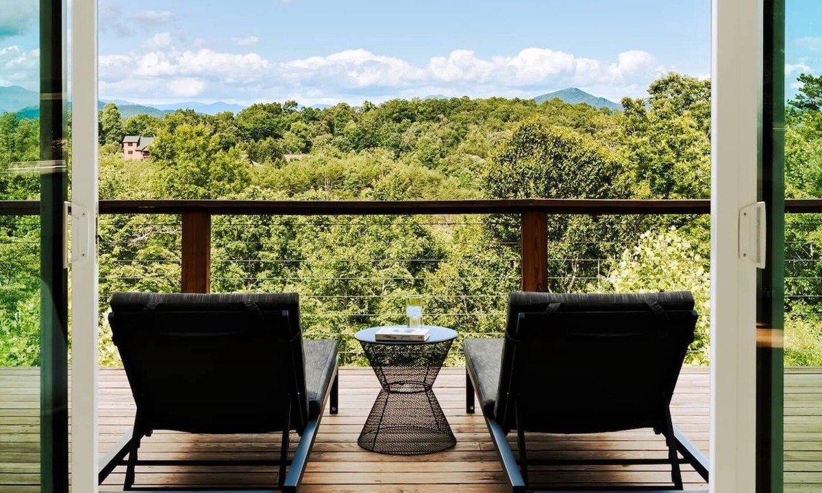 Young Harris Cabin | EcoModMtn is a mountain retreat designed for a stylish winter escape. Enjoy a full kitchen, gas fireplace, ensuite bedrooms, modern interiors, an expansive deck and private hot tub. Perfect for slow morning, cozy evenings, and starry night skies.