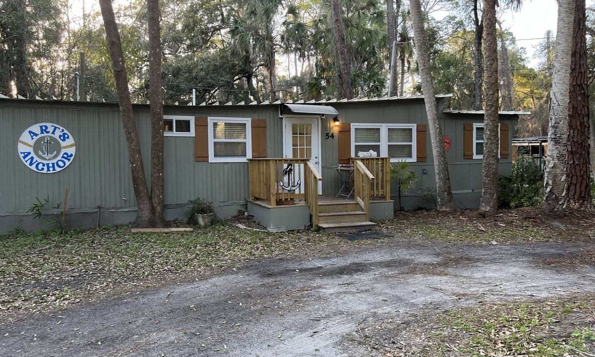 Inglis Apartment | Step into this cozy 2-bedroom cabin nestled in the tranquil woods. The main living area offers comfy seating, including a pull-out futon for additional sleeping space. An efficiency kitchen awaits your culinary adventures, equipped with essentials fo