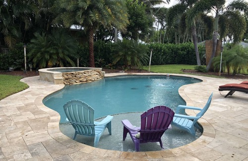 Jupiter House | Tropical waterfront oasis with private dock, pool, waterfall spa, tiki huts.
