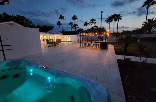 Palma Sola House | 75 Palms! Sleeps 23! Luxury 1 acre lot Pool and Spa, Putting Green & Game Room!