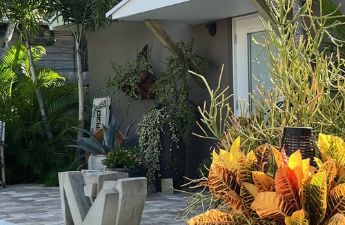 Parrot Cove Cottage | Chill on the patio overlooking the pool & lush gardens with privacy!