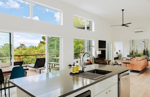 Young Harris Cabin | EcoModMtn is a mountain retreat designed for a stylish winter escape. Enjoy a full kitchen, gas fireplace, ensuite bedrooms, modern interiors, an expansive deck and private hot tub. Perfect for slow morning, cozy evenings, and starry night skies.