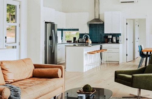 Young Harris Cabin | EcoModMtn is a mountain retreat designed for a stylish winter escape. Enjoy a full kitchen, gas fireplace, ensuite bedrooms, modern interiors, an expansive deck and private hot tub. Perfect for slow morning, cozy evenings, and starry night skies.