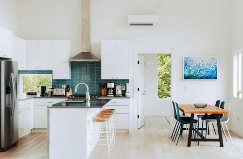 Young Harris Cabin | EcoModMtn is a mountain retreat designed for a stylish winter escape. Enjoy a full kitchen, gas fireplace, ensuite bedrooms, modern interiors, an expansive deck and private hot tub. Perfect for slow morning, cozy evenings, and starry night skies.