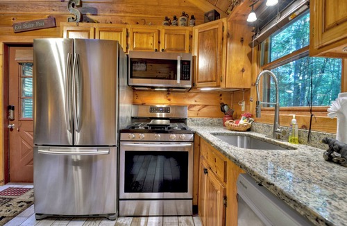 McCaysville Cabin | Nestled by the babbling creek, Creekside Hideaway warmly welcomes pets, offering a hot tub, over-sized screened porch with TV, firepit, and WiFi