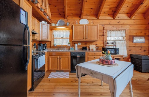 Floyd House | Peaceful log cabin retreat with wraparound deck, open living space, full kitchen, cozy bedrooms & scenic wooded views.