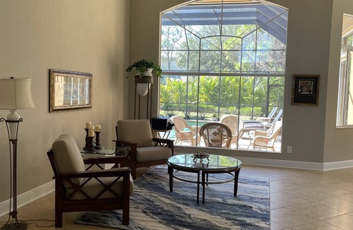Estero House | Renovated open floor plan with large heated pool and screened lanai with dining.