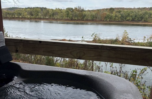 Pleasant Grove Cabin | Riverfront cabin with hot tub and amenities galore!