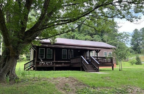 Newland Cabin | Riverfront Luxury Log Cabin with outside fire pit and deck overlooking the water