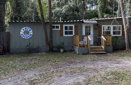 Inglis Apartment | Step into this cozy 2-bedroom cabin nestled in the tranquil woods. The main living area offers comfy seating, including a pull-out futon for additional sleeping space. An efficiency kitchen awaits your culinary adventures, equipped with essentials fo