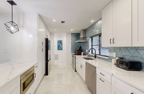 Coral Ridge Isles House | Stunning single level home with, heated pool, kitchen, & fully equipped BBQ area