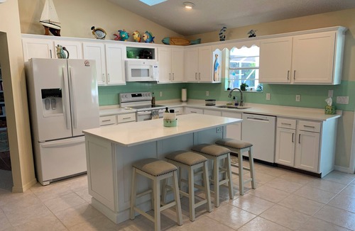 Sebastian Highlands House | Sunny Florida style home with a beautiful covered pool located near the ocean.