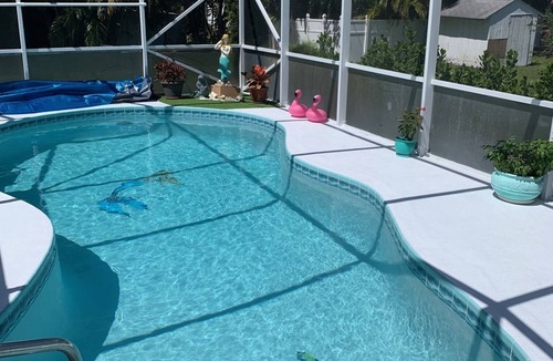 Sebastian Highlands House | Sunny Florida style home with a beautiful covered pool located near the ocean.