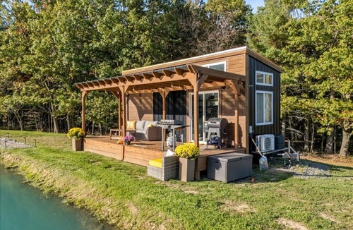 Brackney Cabin | Waterfront Tiny House Perched on the Pond Covered Deck at Water’s Edge