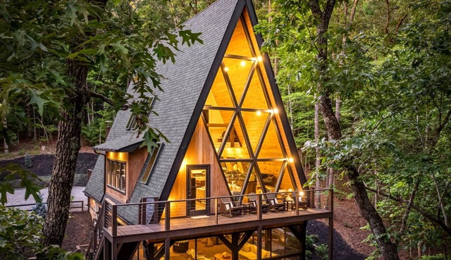 Floor-to-ceiling A-frame glass walls, screened in porch/game room, a pro level putting/chipping green that includes putters, clubs & balls, tranquil pondless waterfall, with a hot tub & fire pit under the stars, massive kitchen, and room for 10!