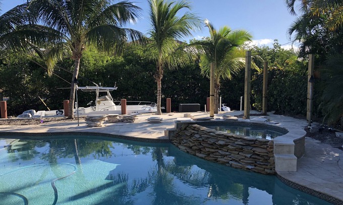 Jupiter House | Tropical waterfront oasis with private dock, pool, waterfall spa, tiki huts.